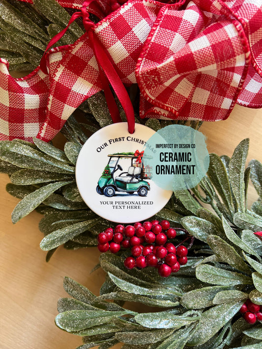 imperfect by design co exclusive Decorative wreath with a read bow and a ceramic ornament featuring a golf cart design on a wooden surface. Teal Text Blurb reads "imperfect by design co Ceramic Ornament"