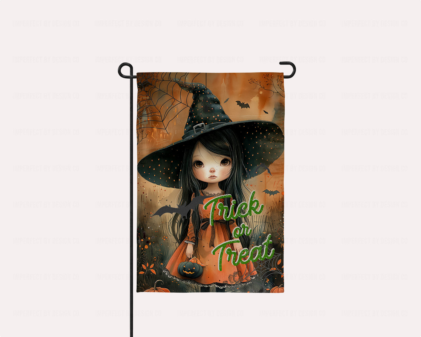 Adorable garden flag featuring a little doe-eyed witch with a black hat and pumpkin treat bucket.