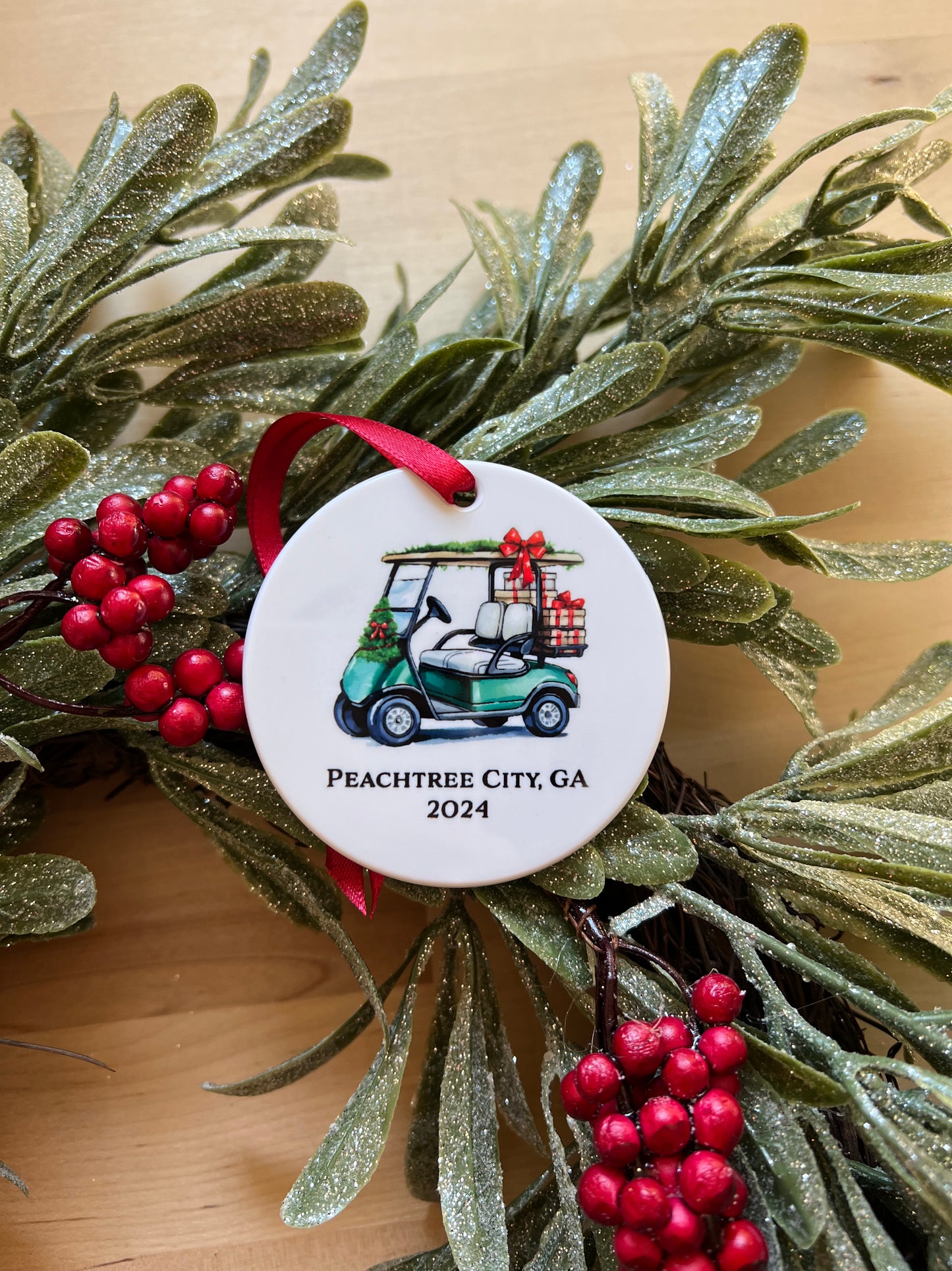 2.7 inch diameter disk Christmas ornament with green golf cart and text "Peachtree City, GA 2024"