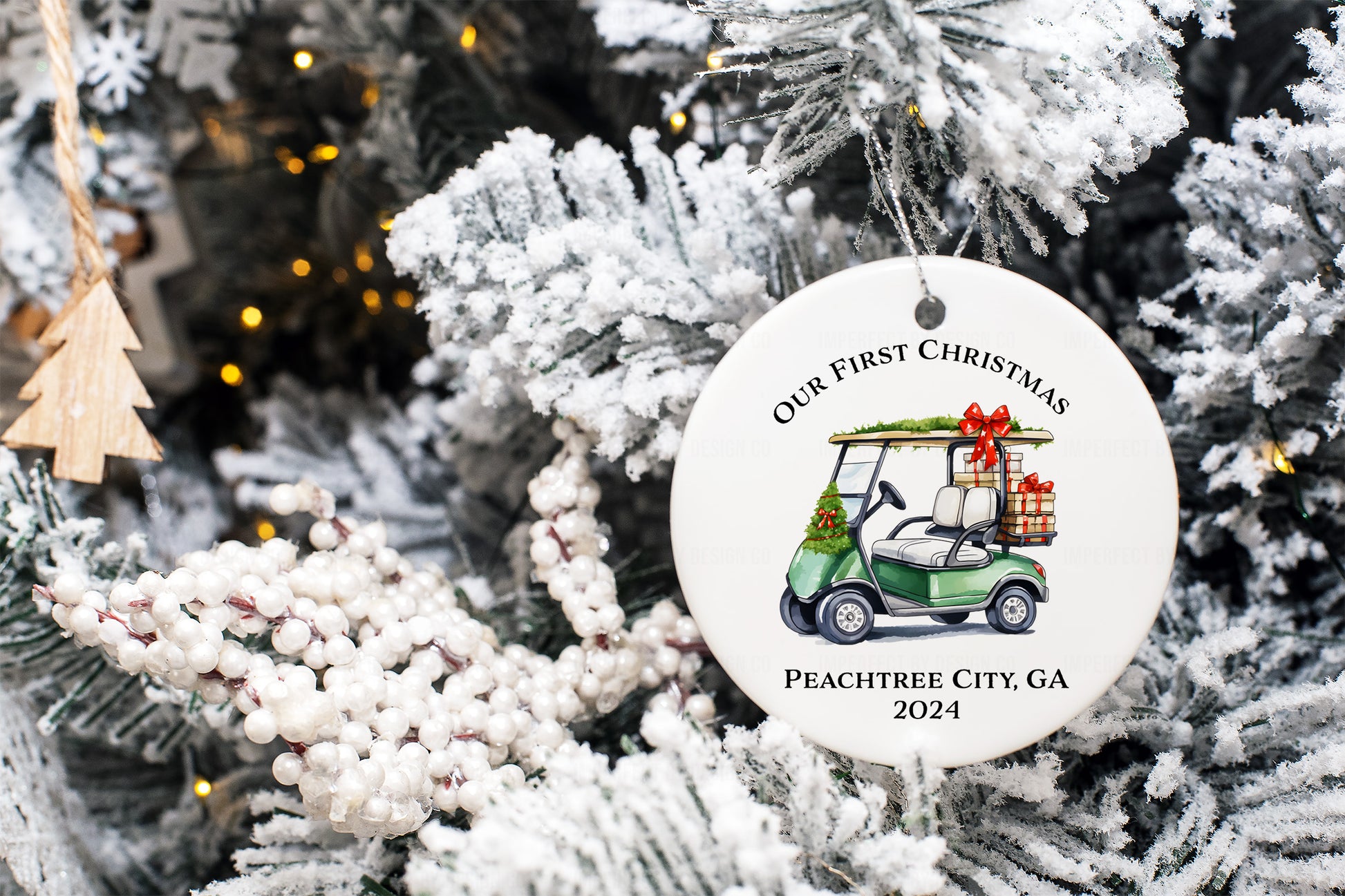 Double-sided personalized "Our First Christmas" golf cart ornament featuring Peachtree City, GA and 2024 text hung on a flocked tree.