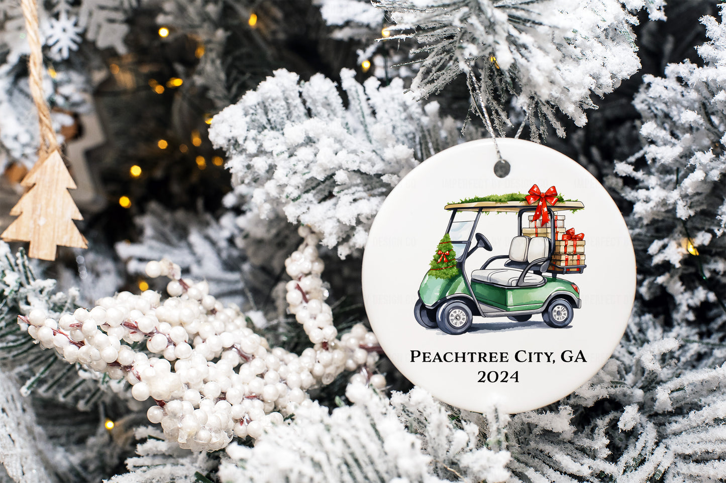 Personalized green golf cart ornament with festive garlands and customizable "Peachtree City, GA 2024" or last name/year text - hung on a flocked tree