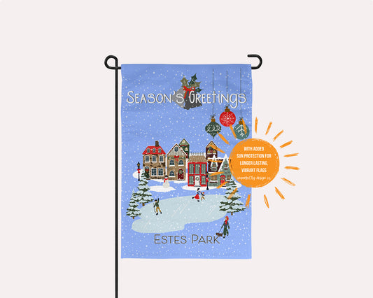 imperfect by design co exclusive Christmas-themed garden flag with a snowy village scene and 'Merry Christmas' text, featuring Leavenworth, WA hanging on a garden flag stand, on a pale pink background.
Sun shaped blurb reads "with added sun protection for longer lasting vibrant flags.