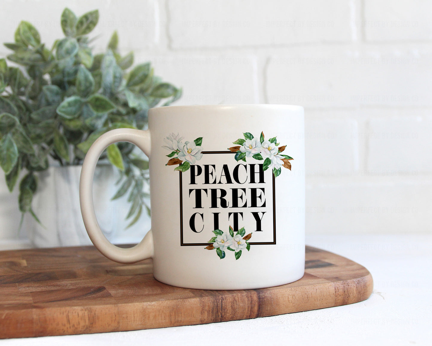 Add a touch of sophistication to your coffee game with our Peachtree City magnolia ceramic mug. Crafted from high-quality ceramic, this 11-ounce mug features an elegant design with a smooth glazed finish for easy cleaning. | imperfect by design co