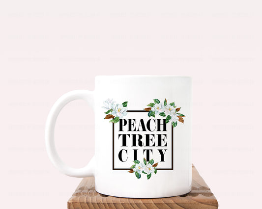 Sip in style with our Peachtree City magnolia ceramic coffee mug, featuring an elegant black frame and stunning magnolia blooms on a crisp white mug showcasing the city's name. Perfect for enjoying your favorite hot or cold beverage in style. | imperfect by design co