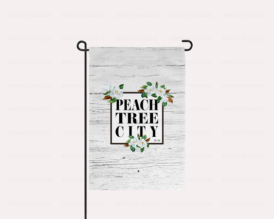 Stunning Magnolia, Peachtree City - Garden Flag with an elegant black frame and beautiful magnolia blooms on a white faux wood background. Durable, weather-resistant material for long-lasting use. A must-have for any Southern garden or yard to show off your love for Peachtree City! | imperfect by design co imperfect by design co