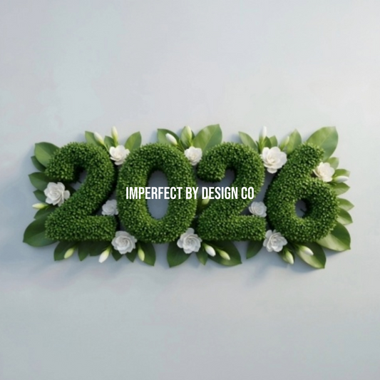 The numbers 2026 written as boxwood hedge flanked by small whit eflowers and green petals. imperfect by design co is written on top in white all cap letters.