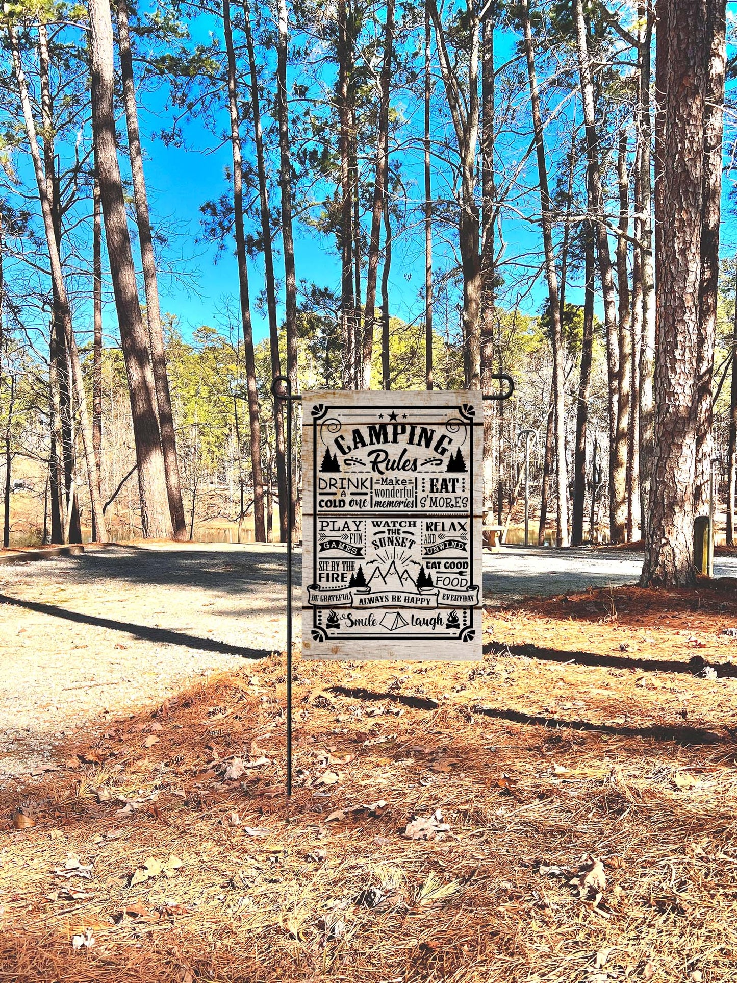 'Camping Rules' garden flag at a campsite in a forest setting with trees and clear sky  | imperfect by design co