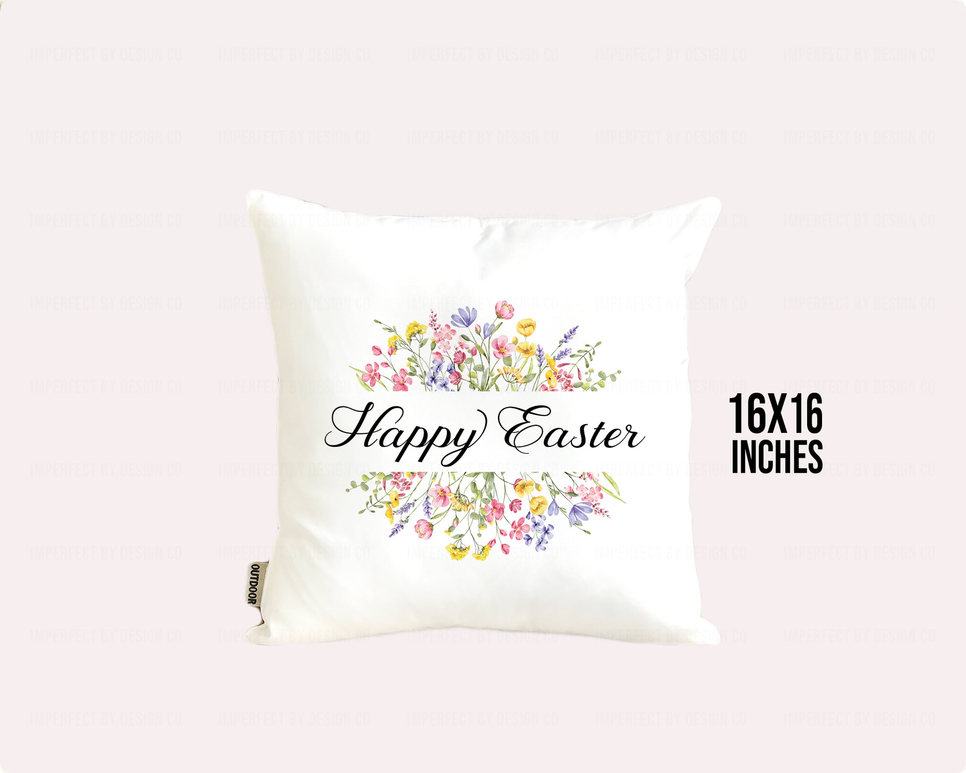 White decorative pillow advertising pillow cover with 'Happy Easter' text and floral designs on a white background 16x16 inches in bold letters on on pale pink background imperfect by design co 