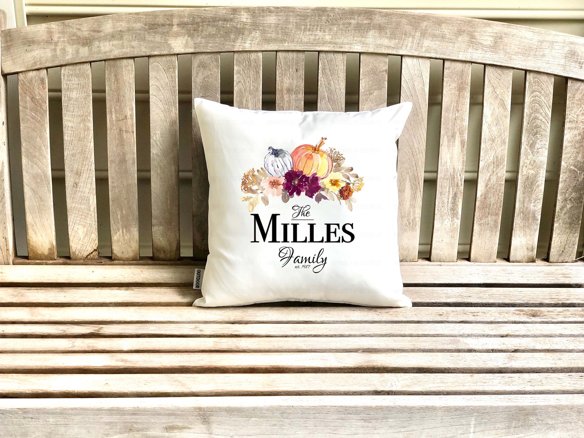Decorative pillow (cover) with 'The Millers Family' text on a wooden porch bench