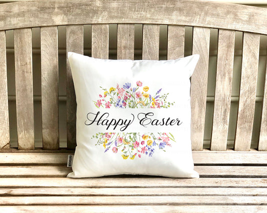 White pillow cover with 'Happy Easter' and floral designs on a wooden bench. imperfect by design co 