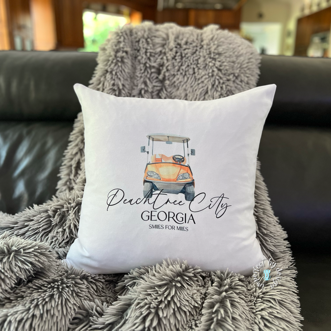 Full view of the Peachtree City decorative pillow cover with golf cart and “Smiles for miles” text.
