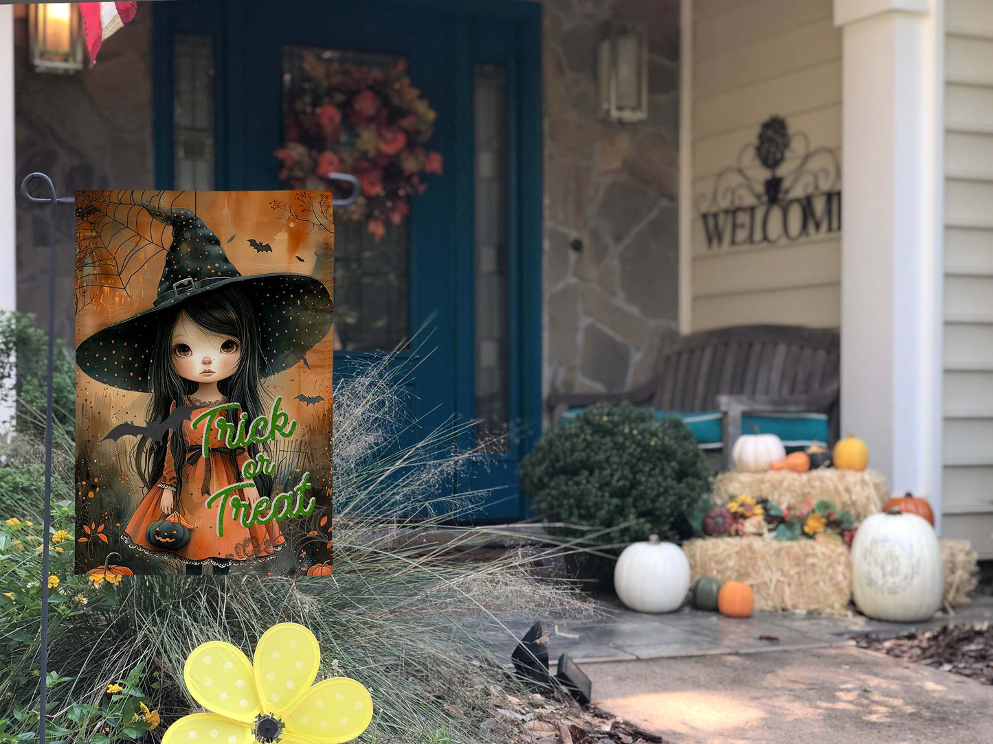 Trick or Treat cute witch garden flag on decorated front porch.