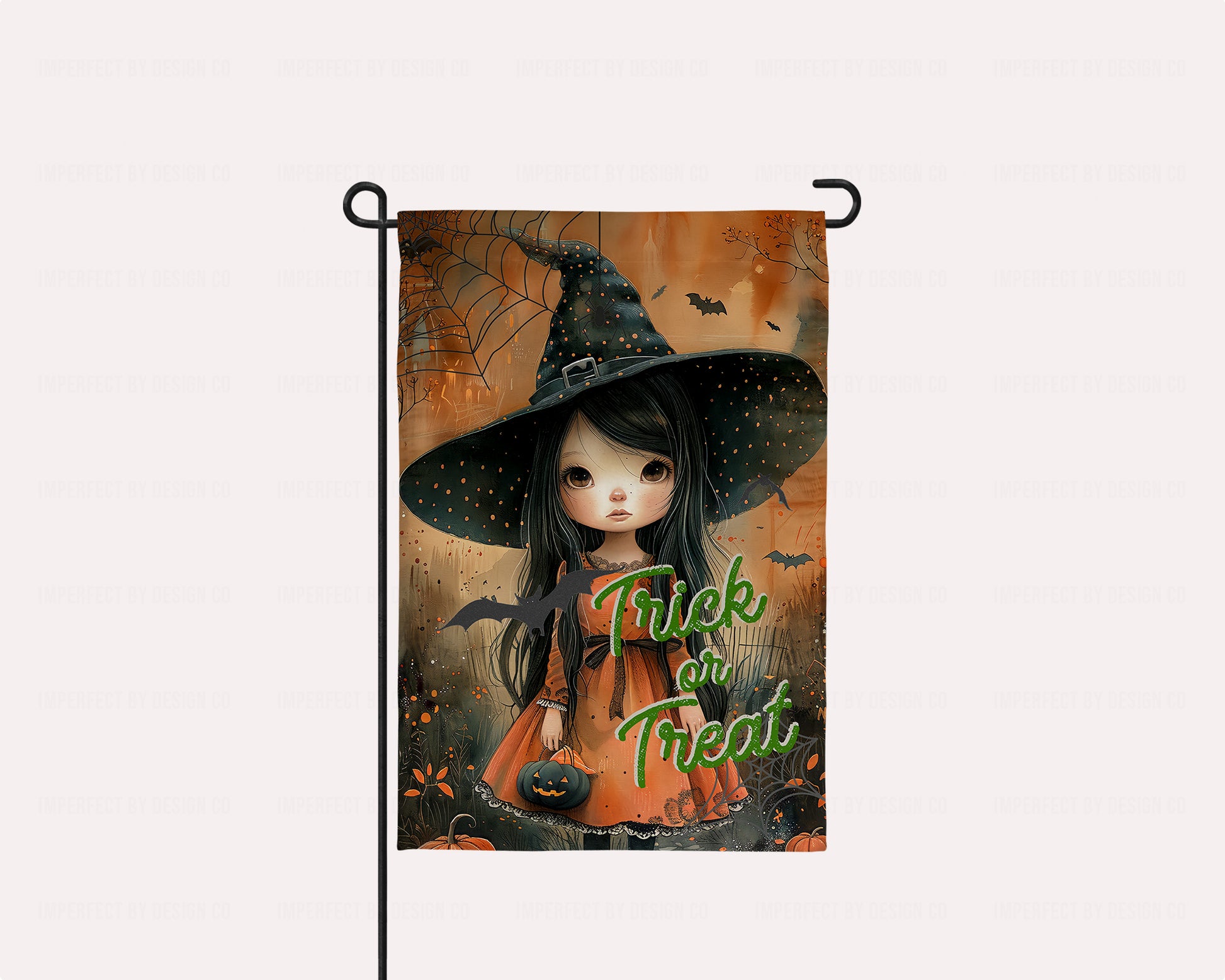 Adorable garden flag featuring a little doe-eyed witch with a black hat and pumpkin treat bucket.