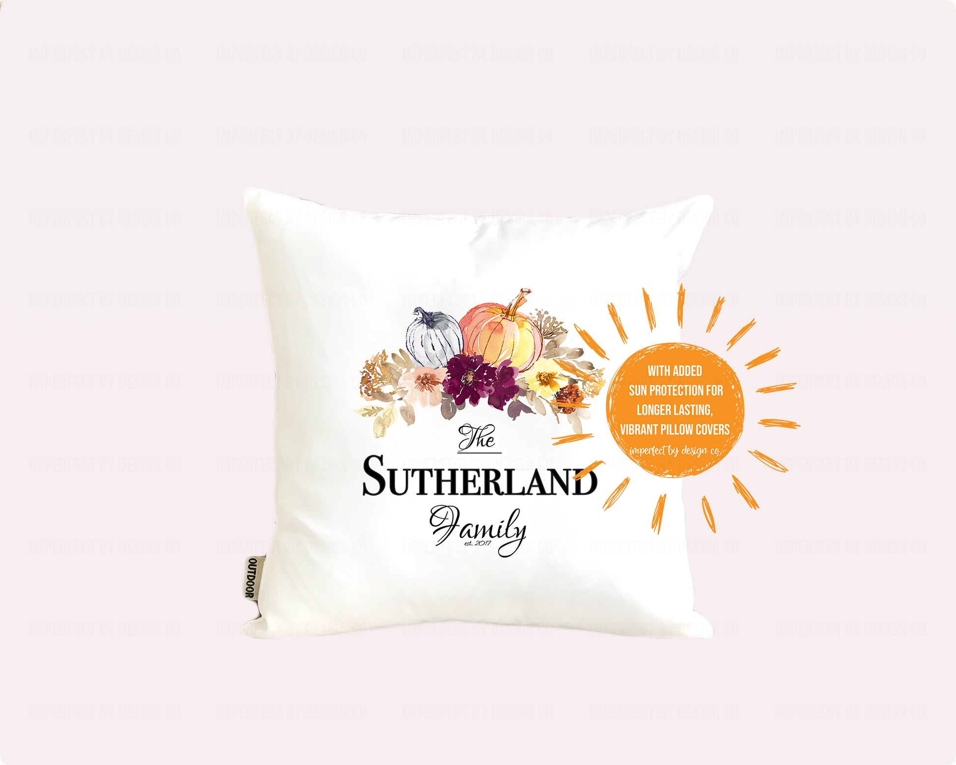 Decorative pillow with 'The Sutherland Family' text and autumn-themed design on a pale pink background. Sun shaped blurb reads 'with added sun protection for longer lasting vibrant pillow covers imperfect by design co'