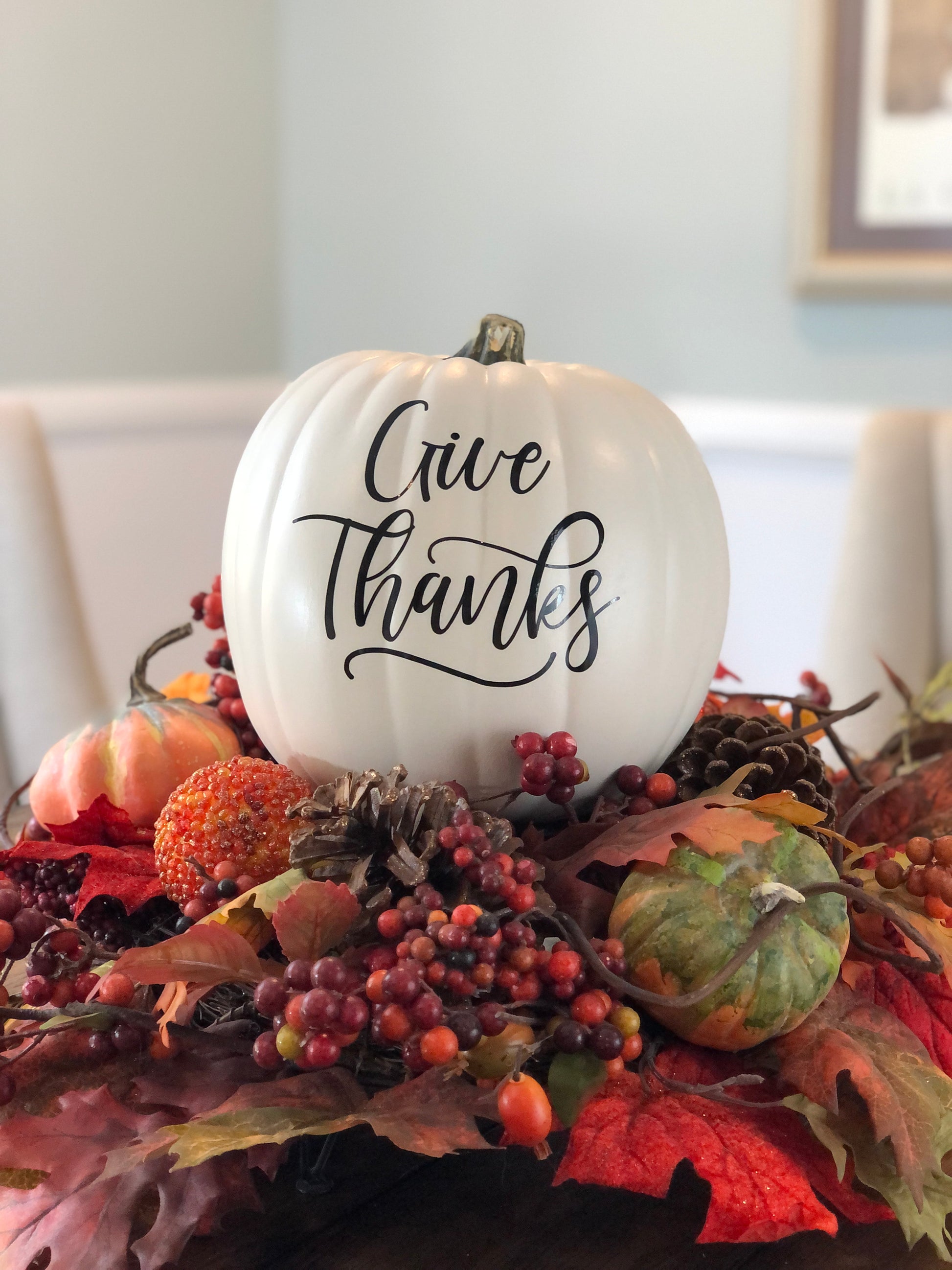 Medium antique white pumpkin with Give Thanks text in black on holiday table setting
