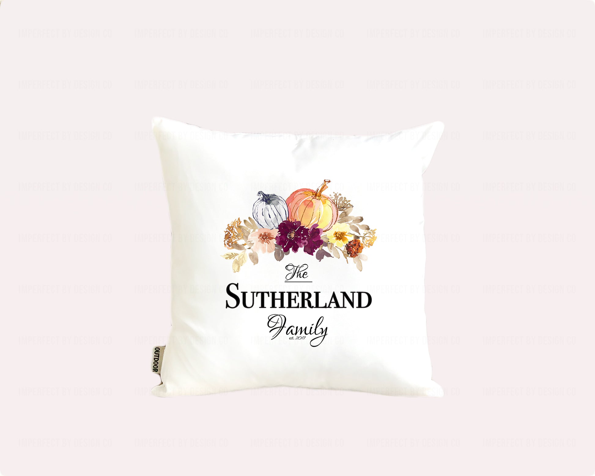 Decorative pillow with autumn-themed design and 'The Sutherland Family' text on a pale pink background