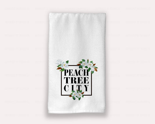 15x25 inches A luxurious white hand towel with Magnolia Blossoms and "Peachtree City" boldly printed in black, perfect for guest bath rooms | imperfect by design co