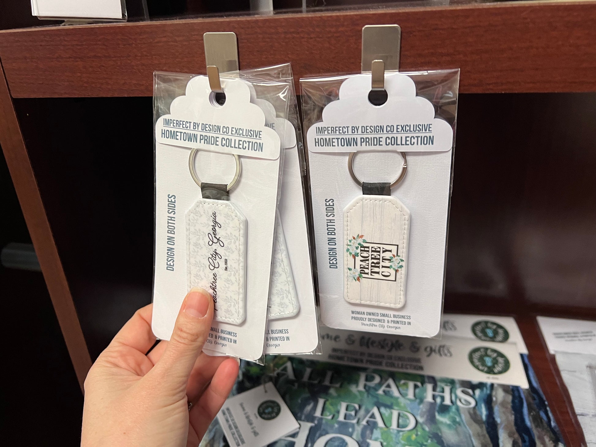imperfect by design co exclusive designs on two key chains in retail setting