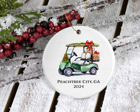 Double-sided Christmas ornament featuring a green golf cart loaded with gifts, customizable with city, state, or family name.