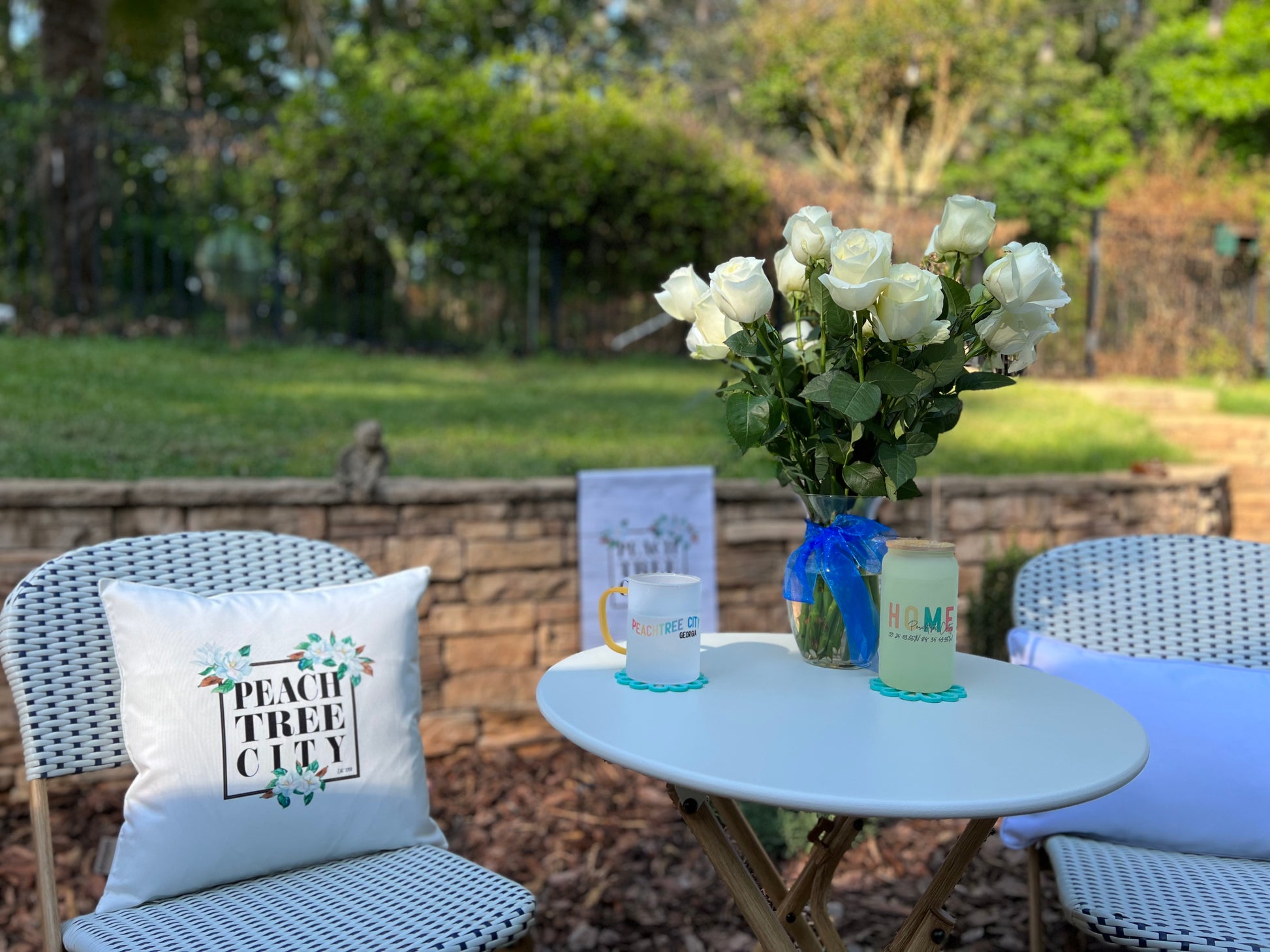 16x16 Indoor Outdoor Pillow Cover Featuring Prominent Magnolia Graphics and text that reads "Peach Tree City"  in square graphic in Bistro Setting | imperfect by design co