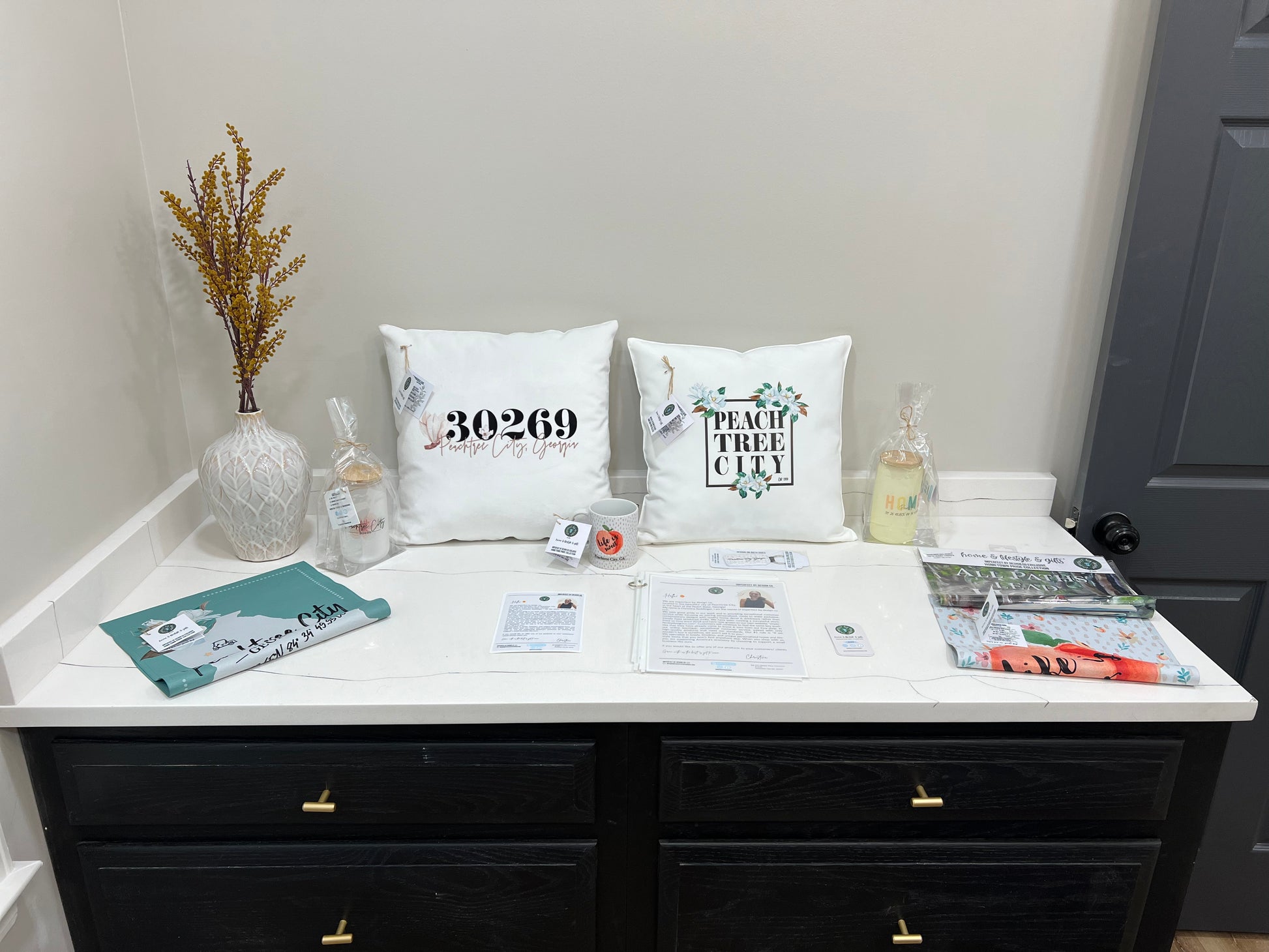 Display of imperfect by design co Products (Velvet Peachtree City Zip Code Pillow, Indoor/Outdoor Magnolia Peachtree City Pillow, Color Changing Home Frosted Tumbler, Peachtree City, Georgia Garden Flag, All Paths Lead Home Peachtree City Garden Flag, Life is Sweet Peachtree City Garden Flag, Peachtree City Frosted Peach Blossom Frosted Tumbler, Peachtree City Life is Sweet 11oz Coffee Mug, Peachtree City Whimsical Key Chain and imperfect by design co Flyers, Product Info and Business Cards