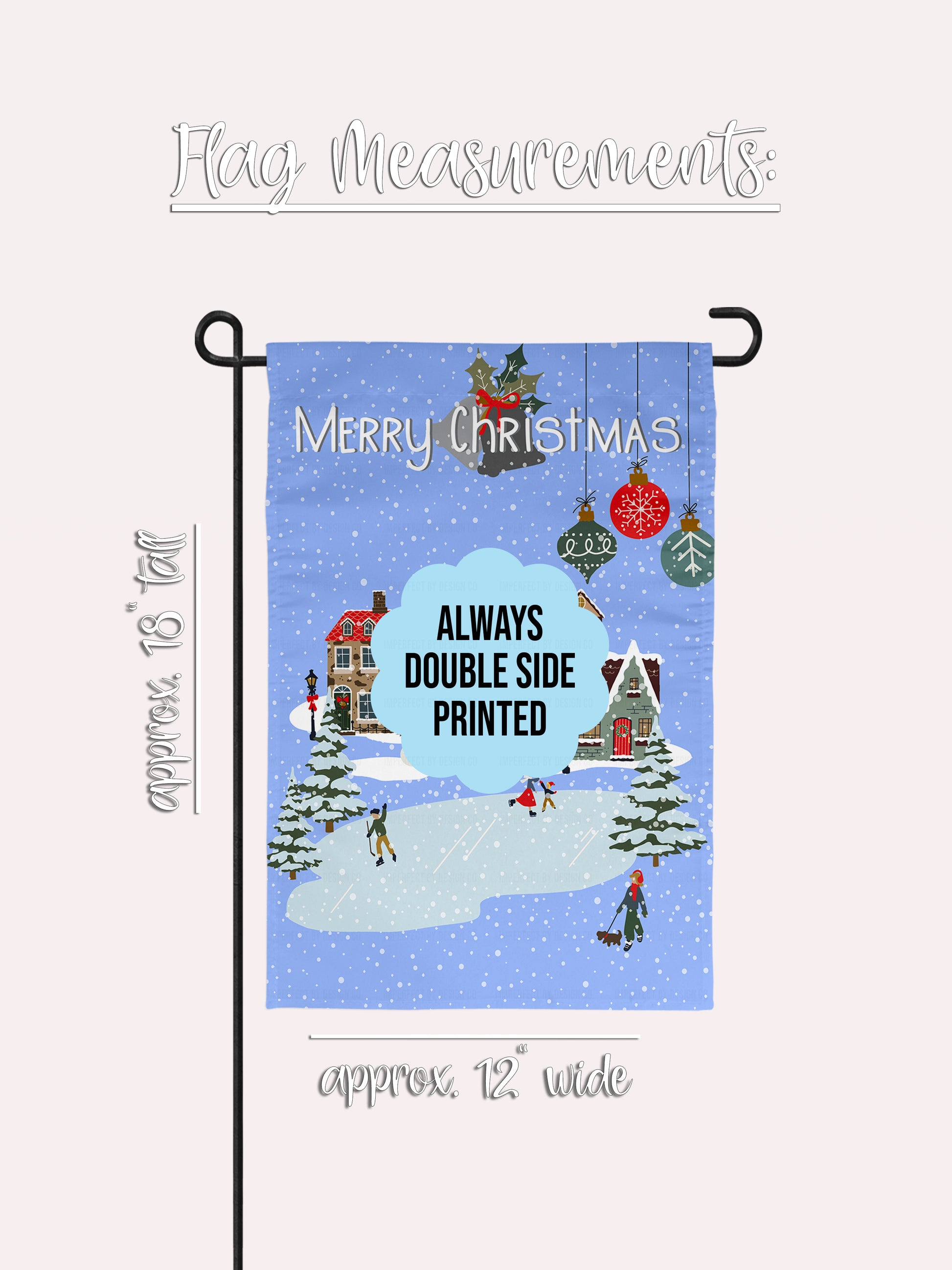 imperfect by design co exclusive design. Christmas-themed garden flag with a winter village scene and 'Merry Christmas' text on a blue background with snowflakes and Christmas tree bulbs. This flag is not personalized. The flag is on a flag stand placed on a pale pink background. Additional information on the background read 'Flag Measurements' 'approximately 18"tall and approximately 12" wide. Show the measurements of the flag.