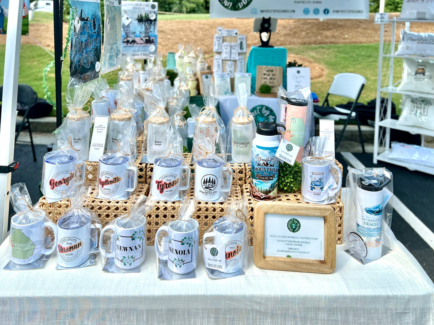 imperfect by design co at vendor event. Display showcases coffee mugs and tumblers for purchase