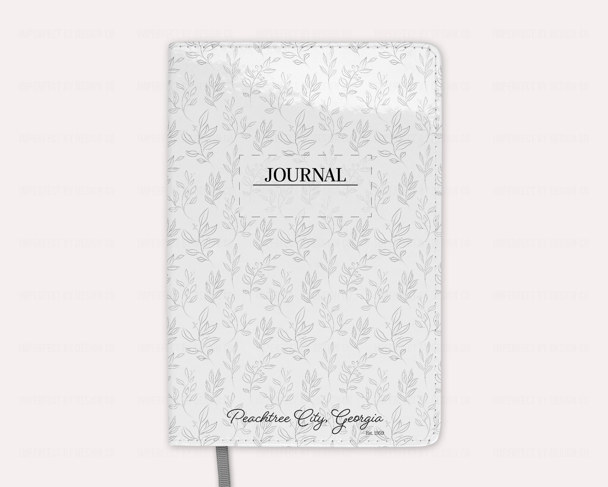 Jot down your thoughts and ideas with our Peachtree City Georgia est. 1959 notebook/journal featuring a whimsical grey leaves motif background. With 100 lined pages and a durable cover, this notebook/journal is both stylish and functional. | imperfect by design co
